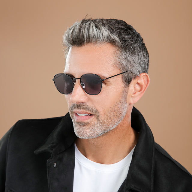 Man with salt and pepper hair and beard looking to his right wearing Prince Sunglasses Black with Grey Flat