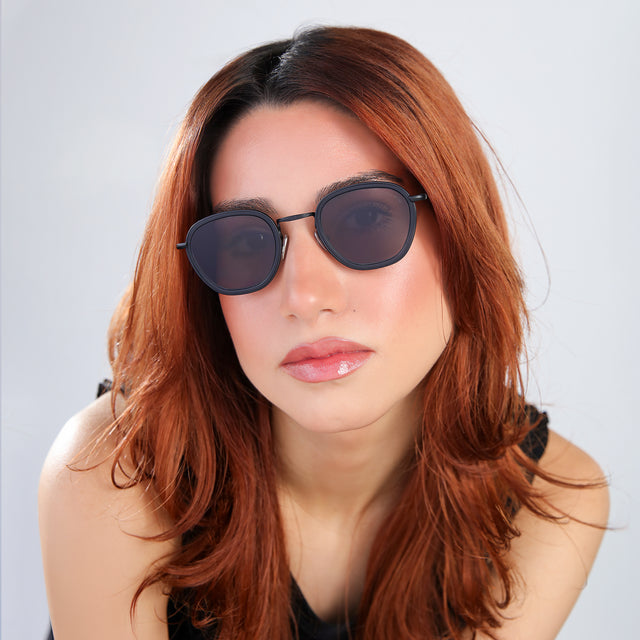 Close up of woman with red hair in a black blouse wearing Prince Tate Sunglasses Matte Black with Grey Flat