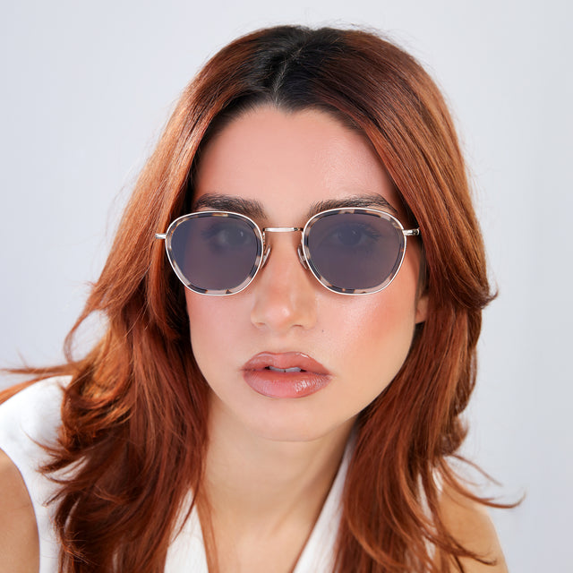 Woman with red hair in a white blouse wearing Prince Tate Sunglasses White Tortoise/Gold with Grey Flat