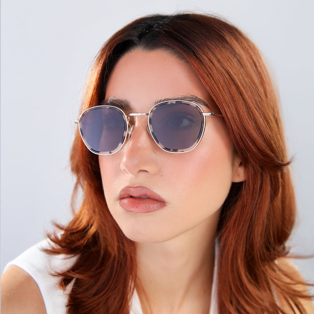 Another angle of woman with red hair in a white blouse wearing Prince Tate Sunglasses White Tortoise/Gold with Grey Flat