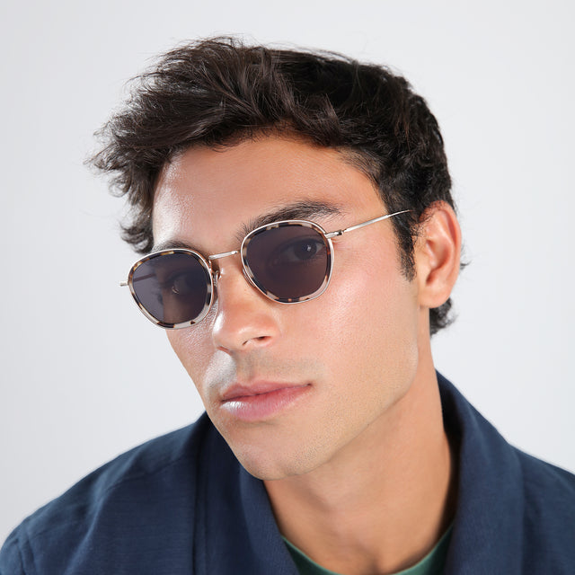 Man in a navy jacket Prince Tate Sunglasses side view in White Tortoise/Gold / Grey Flat