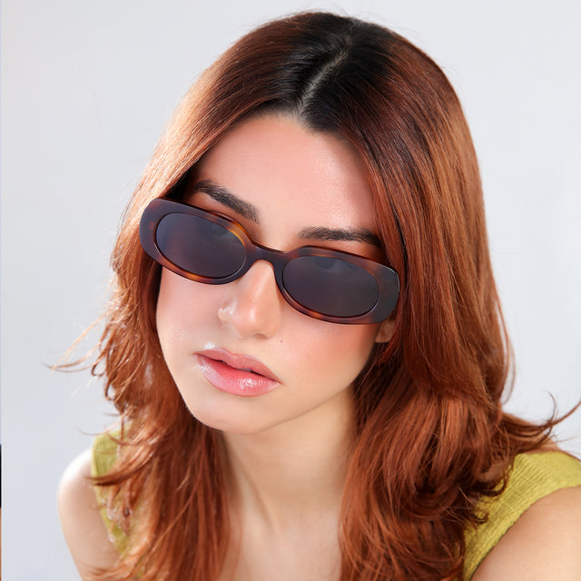 Close up of woman with red hair in a chartruese blouse Shirley 51 Sunglasses side view in Havana / Grey