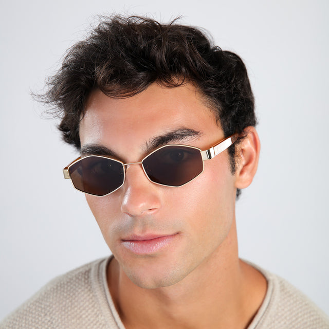 Man in a beige waffled sweatshirt wearing Tucson Sunglasses Gold/Honey with Brown