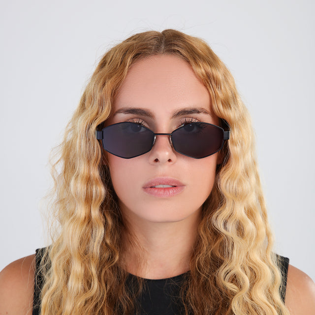 Another angle of model with blonde, wavy hair wearing Tucson Sunglasses Matte Black with Grey