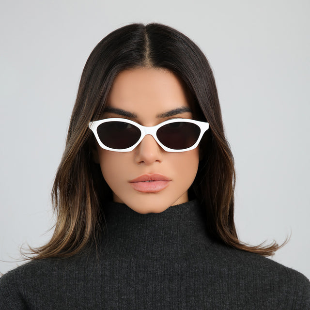 Brunette woman in a black cashmere turtleneck wearing Vilma Sunglasses Light Grey with Grey