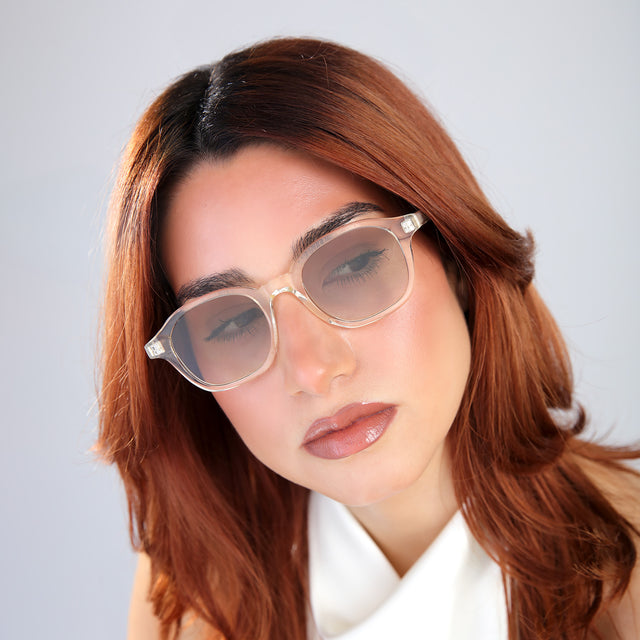 Another angle of woman with red hair in a white blouse wearing William Sunglasses Champagne with Taupe Gradient