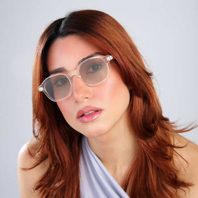 Woman with red hair in a baby blue blouse wearing William Sunglasses Champagne with Taupe Gradient