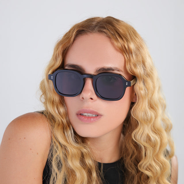 Blonde woman with curly hair wearing Washington Sunglasses Black with Grey Flat