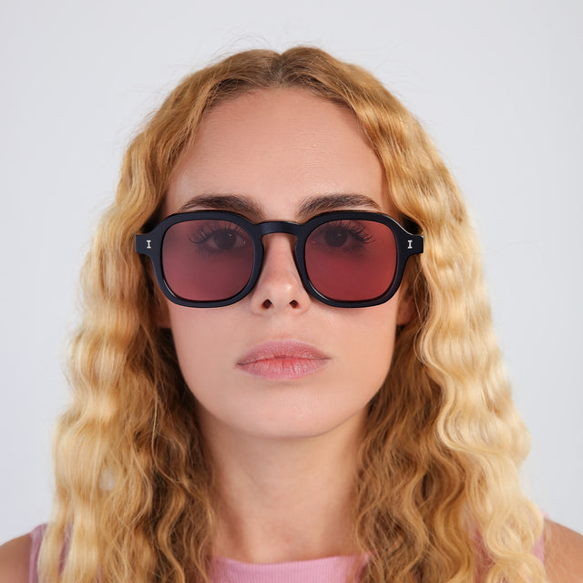 Blonde woman with curly hair wearing Washington Sunglasses Black with Bordeaux Flat See Through