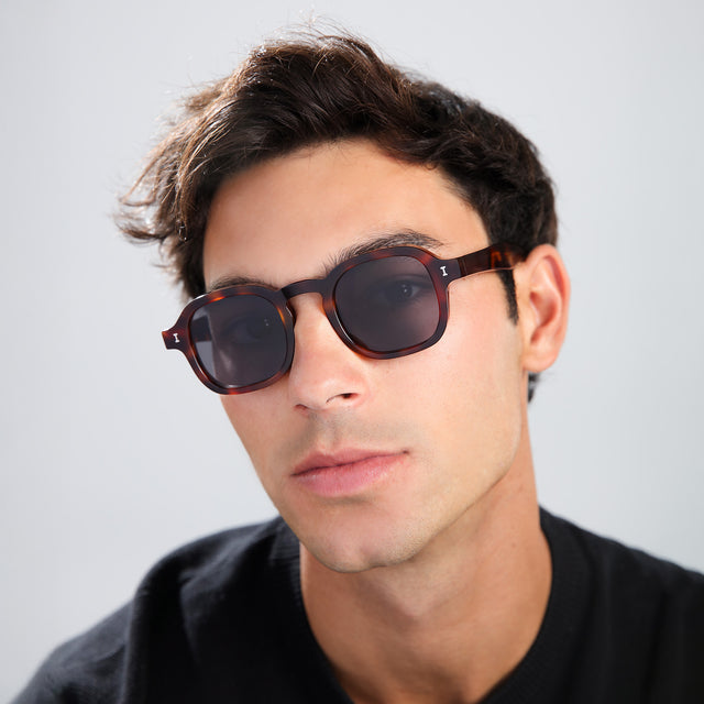 Man with brown hair in a black shirt wearing Washington Sunglasses Havana with Grey Flat