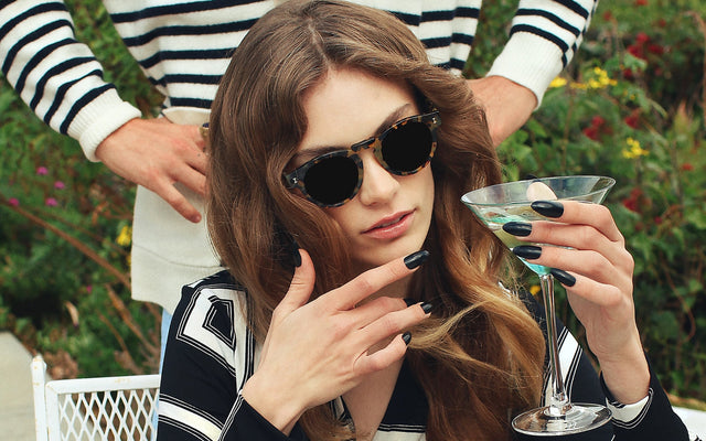 Woman sipping a cocktail wearing the Leonard Sunglasses
