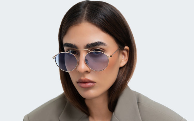 Woman in a blazer wearing the Wynwood M in Gold with Blue Gradient See Through
