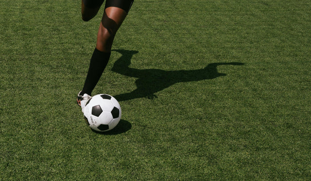 Player winding their leg back back about to kick a soccer ball
