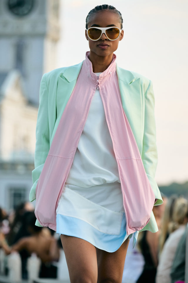 Model in a pastel jacket walking the runway in Cynthia Rowley x illesteva