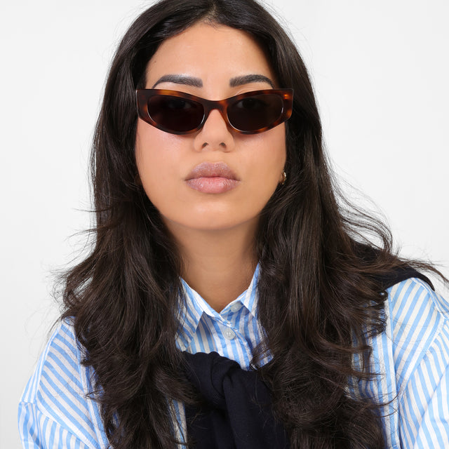 Brunette model in a blue and white striped blouse wearing Alexa Sunglasses Havana with Grey Flat