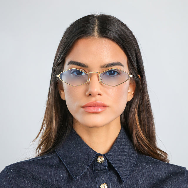 Woman in a dark blue denim jacket wearing Astoria Sunglasses Gold with Blue Flat Gradient See Through