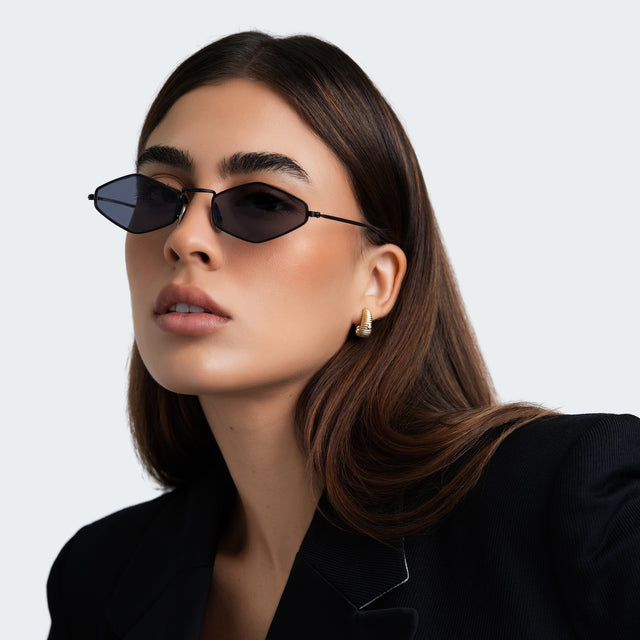 Another angle of a woman in a black blazer wearing Astoria Sunglasses Matte Black with Grey Flat