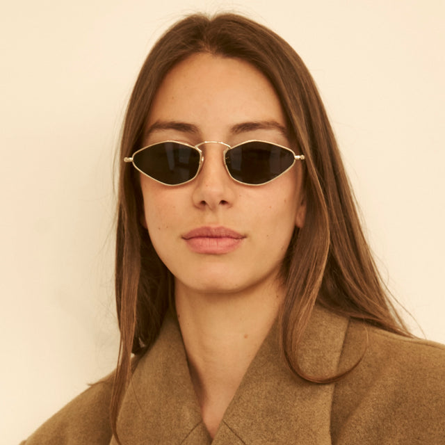 Woman in a camel coat wearing Austria Sunglasses Gold with Grey Flat