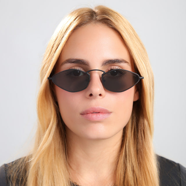 Another angle of blond woman in a black tee wearing Austria Sunglasses Matte Black with Grey Flat