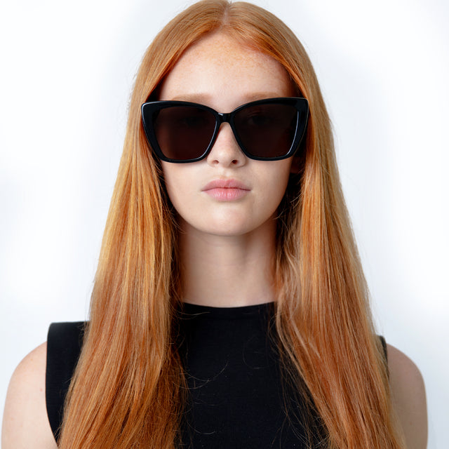 Model with straight red hair wearing Barcelona Sunglasses Black with Grey Flat