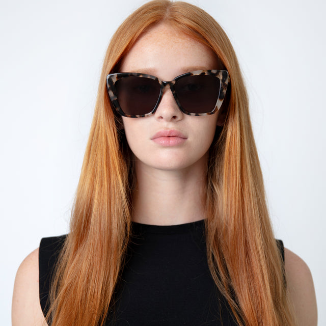 Model with straight red hair wearing Barcelona Sunglasses White Tortoise with Grey Flat