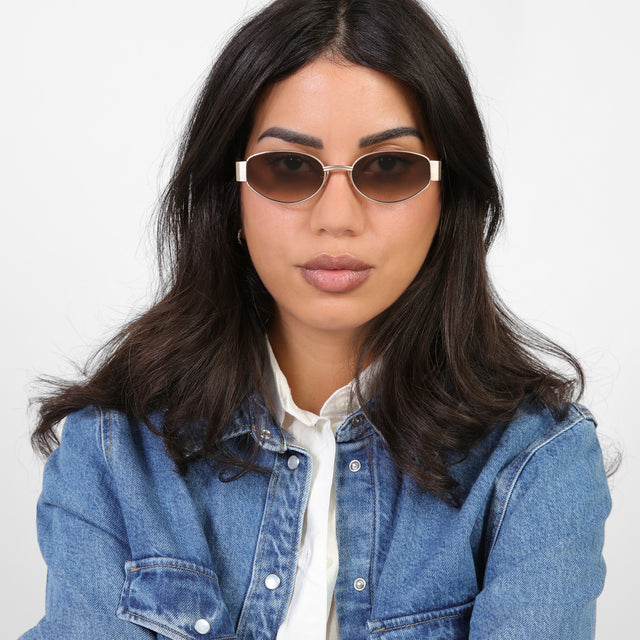 Brunette model in a denim jacket wearing Bellagio Sunglasses Brushed Rose Gold with Taupe Gradient