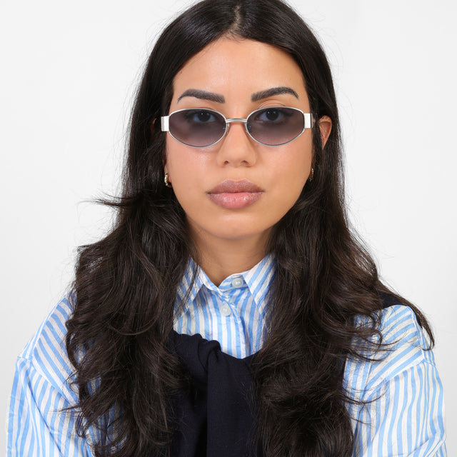 Brunette model in a blue and white striped blouse wearing Bellagio Sunglasses Brushed Silver with Midnight Blue Gradient