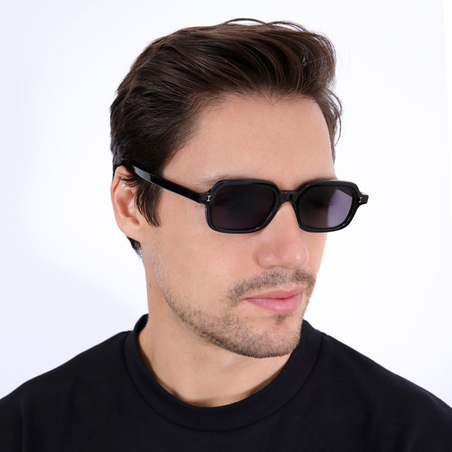 Model with short brown hair combed sideways wearing Berlin Sunglasses Black with Grey