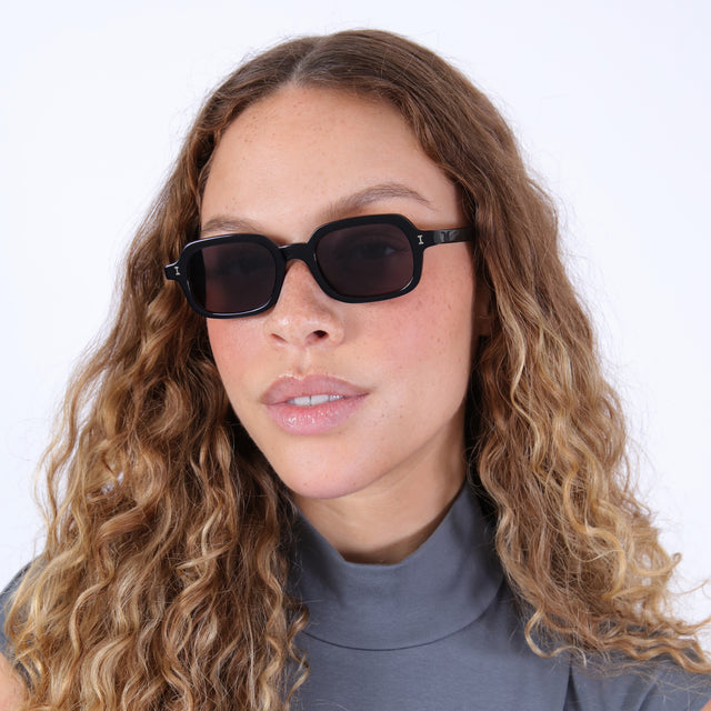 Brunette model with ombré, wavy hair wearing Berlin Sunglasses Black with Grey