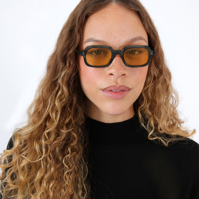 Brunette model with ombré, natural curls wearing Berlin Sunglasses Shadow with Honey See Through