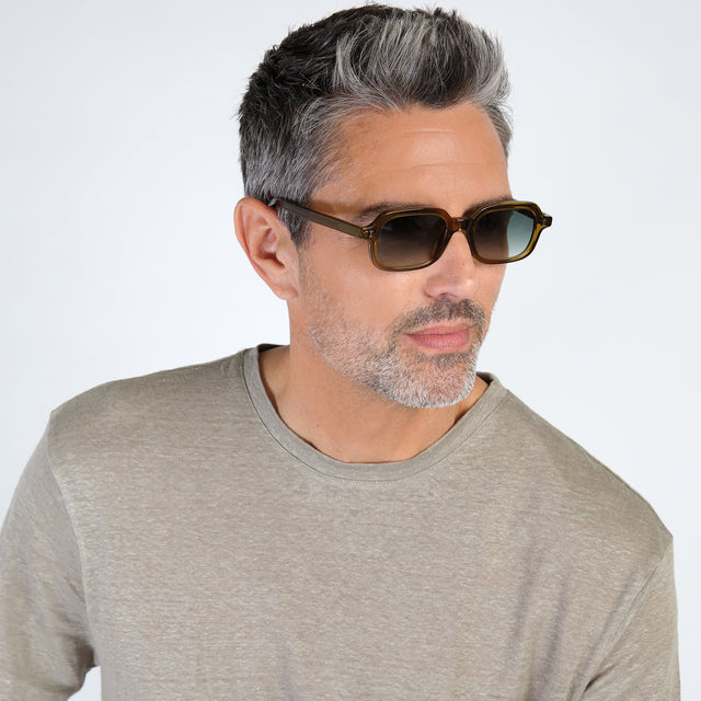 Male model looking left wearing Berlin Sunglasses Moss with Olive Gradient