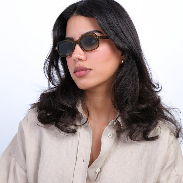 Brunette model with loose curls wearing Berlin Sunglasses Moss with Olive Gradient