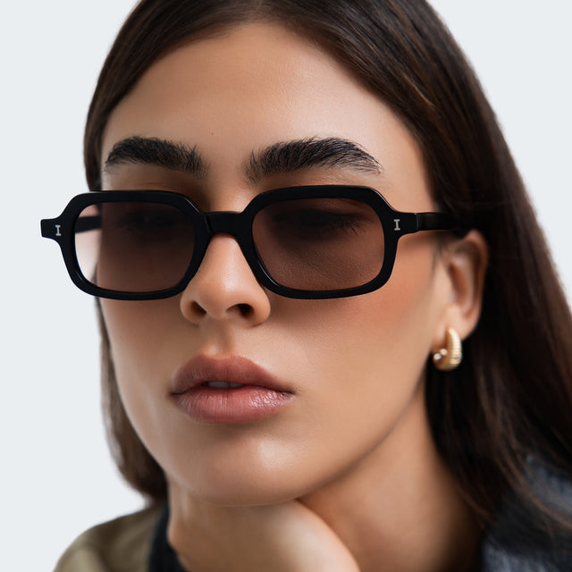 Close up of a woman in a trench coat wearing Berlin Sunglasses Black with Brown Gradient