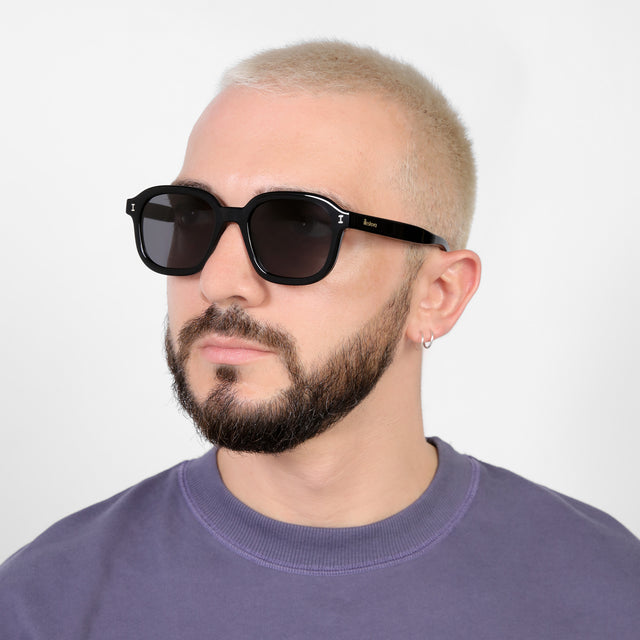 Bearded model looking right wearing Bogota E Sunglasses Black with Grey Flat