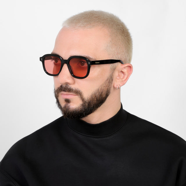 Bearded model looking right wearing Bogota E Sunglasses Black with Guava See Through