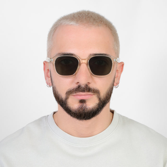 Model with a platinum buzzcut wearing Bogota E Sunglasses Champagne with Olive Flat