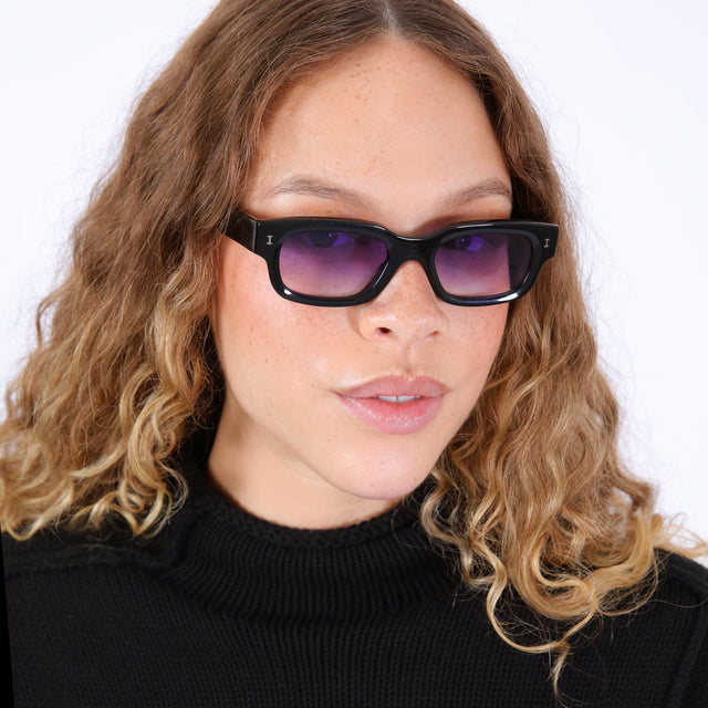 Brunette model with wavy ombre wearing Cali Sunglasses Black with Purple Gradient