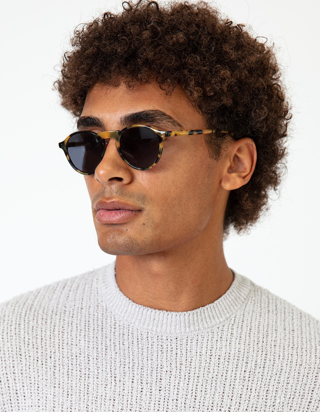 Model in a knit sweater wearing Capri Sunglasses in Tortoise with Grey