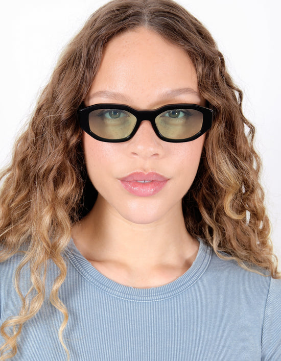 Model wearing Cassette Sunglasses in Black with Mint Flat See Through