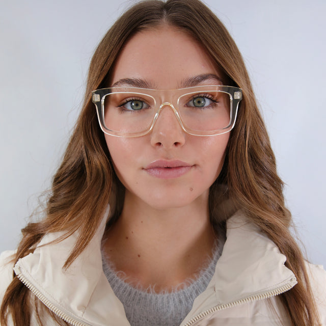 Brunette model in a white puffer jacket wearing Catania Optical Champagne Optical