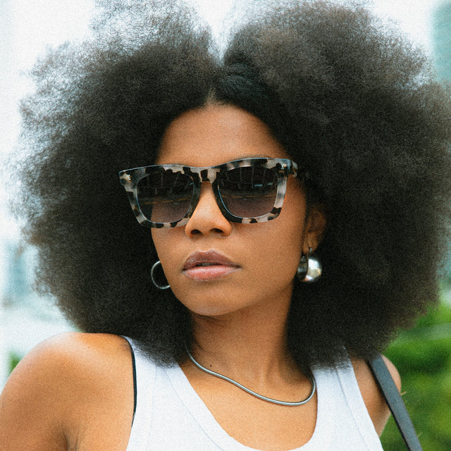 Model with afro-textured hair in a park wearing Charleston Sunglasses White Tortoise with Grey Flat Gradient