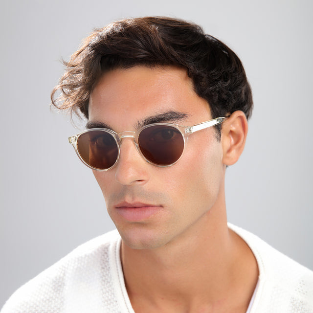 Man with brown hair in a beige waffled sweatshirt wearing Como Sunglasses Champagne with Brown