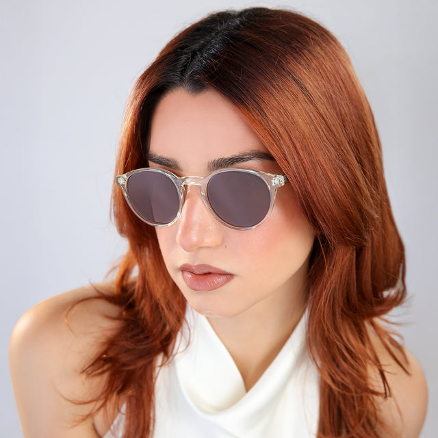Woman with red hair in a white blouse looking right Como Sunglasses side view in Champagne / Brown