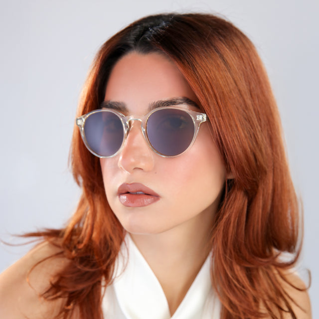 Another angle of woman with red hair in a white blouse looking right Como Sunglasses side view in Champagne / Brown