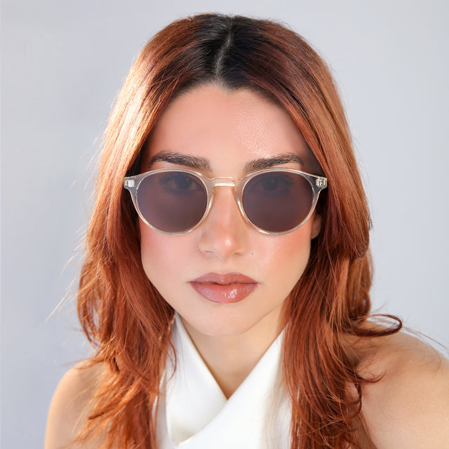 Close up of woman with red hair in a white blouse looking right Como Sunglasses side view in Champagne / Brown