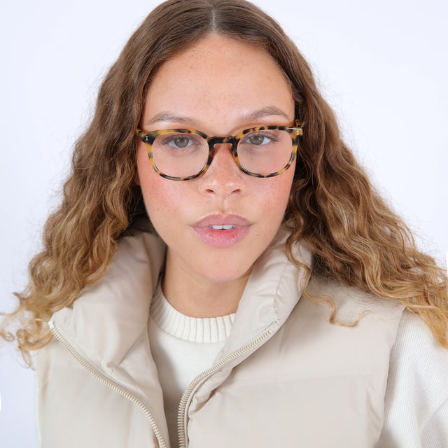 Brunette model with ombré, curly hair wearing Copenhagen Optical Tortoise Optical