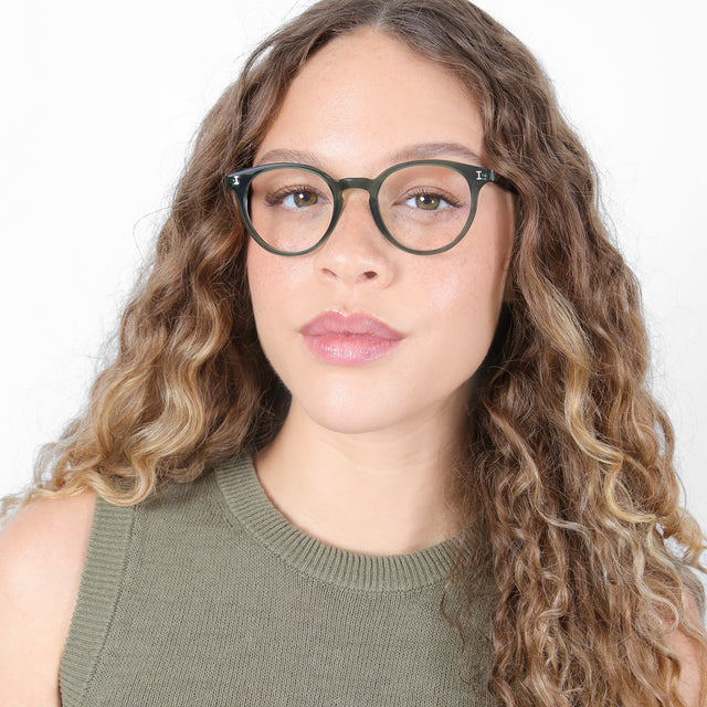 Brunette model with ombré, natural curls wearing Dakota Optical Pine Optical