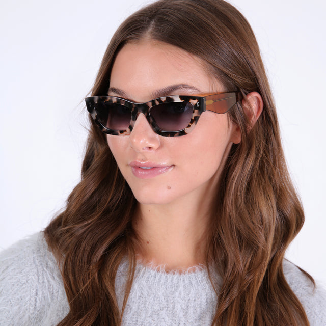 Brunette in a fluffy sweatshirt wearing Donna Sunglasses White Tortoise/Cider with Grey Gradient