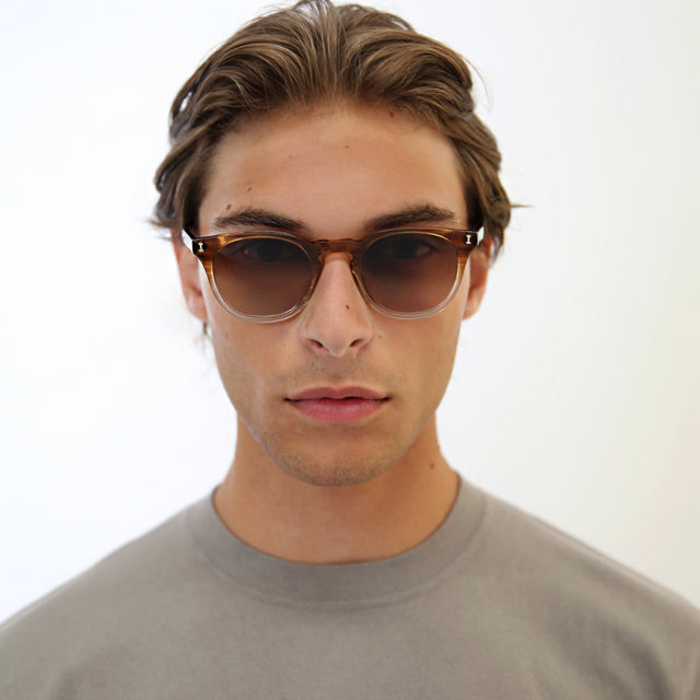 Model with light brown hair combed back wearing Eldridge 48 Light Sunglasses Natural Oak with Brown Flat Gradient