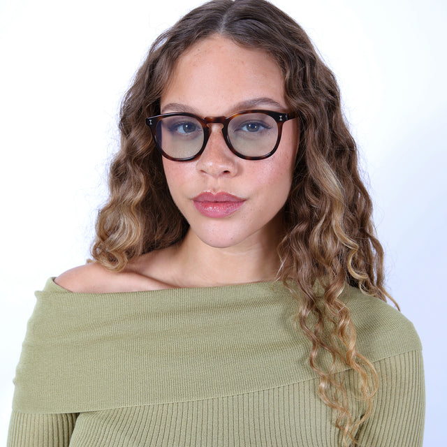 Brunette model with ombre, natural curls wearing Eldridge Sunglasses Havana with Sage Flat See Through